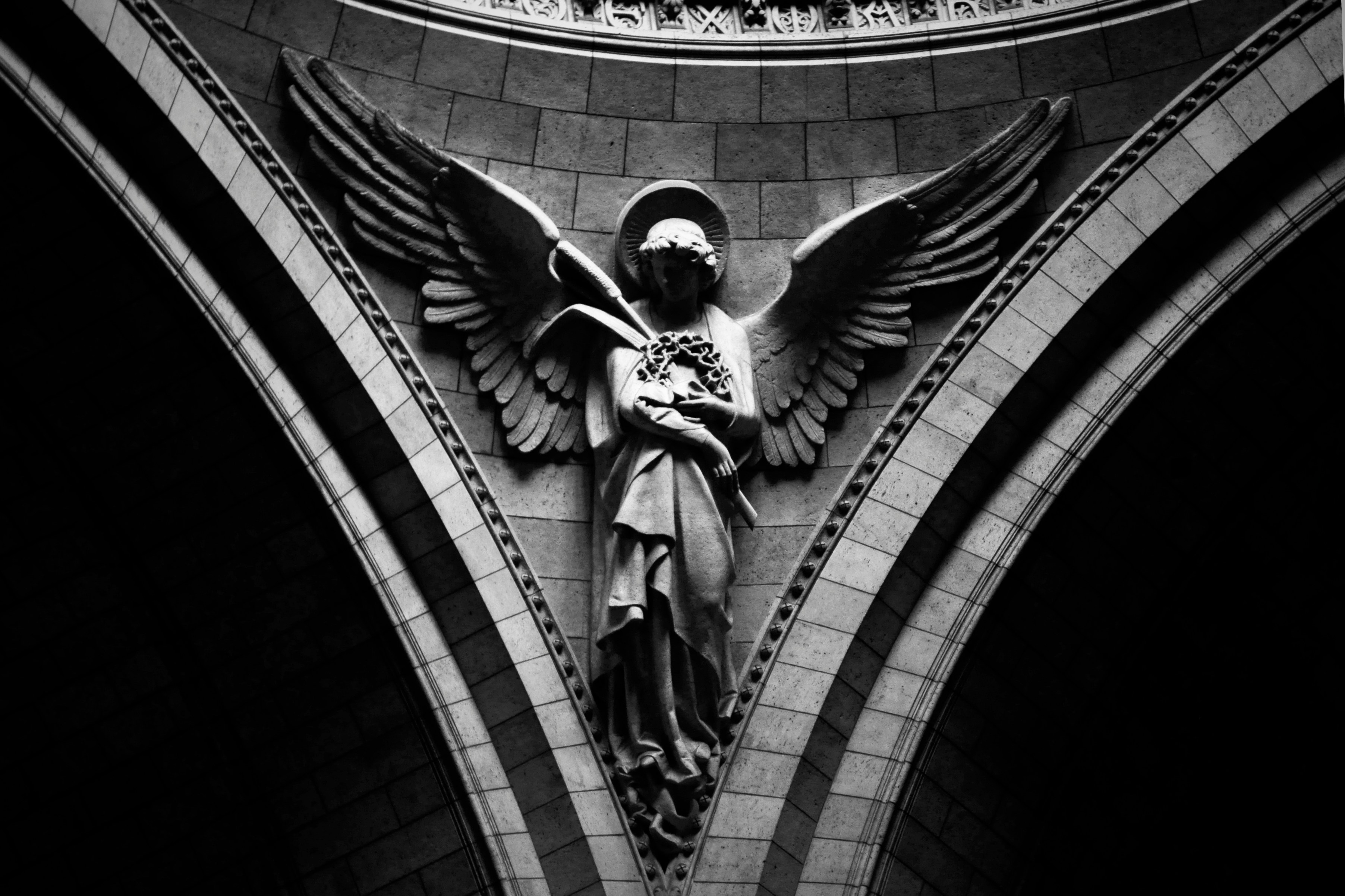 photo of an angel statue in light and shadow